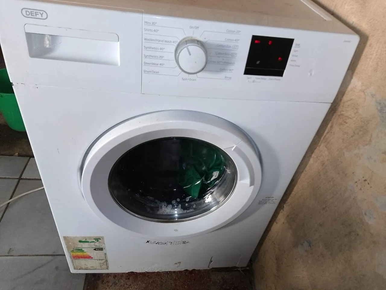 Defy front loader washing machine with washing and water left sitting in the drum after the cycle has finished