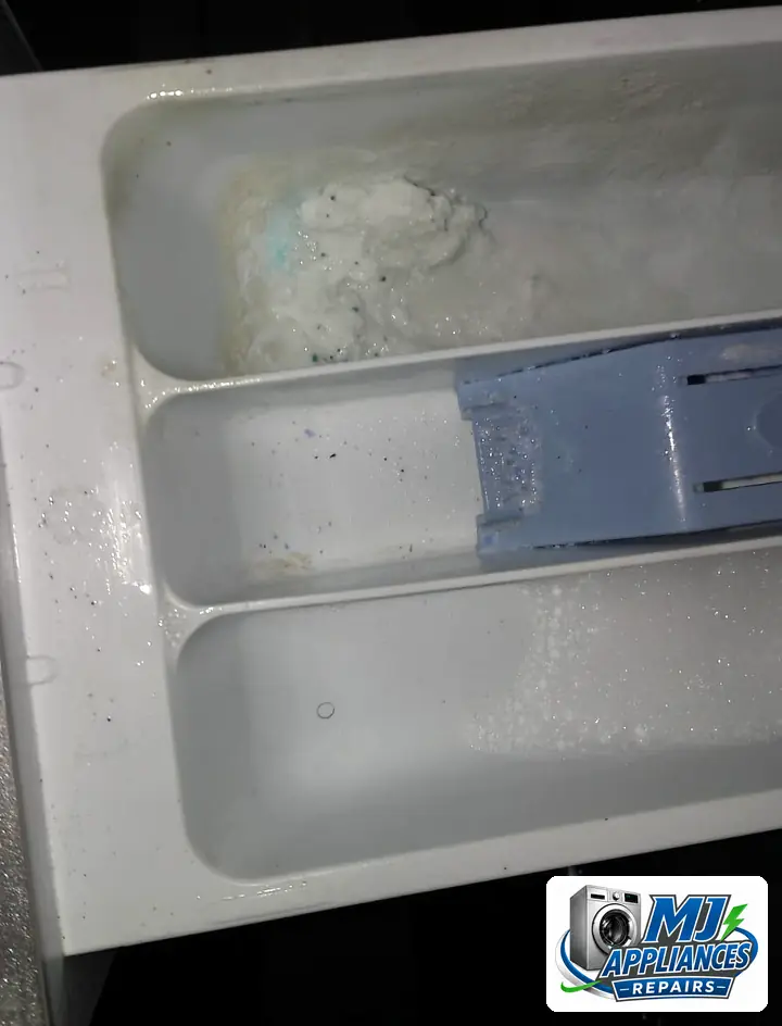 Undissolved hand-wash powder caked in a washing machine detergent drawer